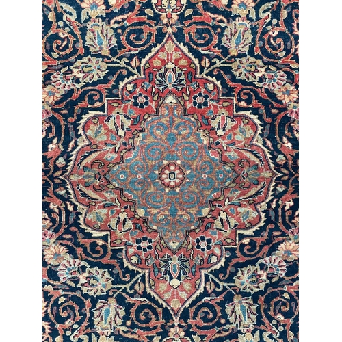 152 - A Kashan rug, Central Persia, circa 1920. The dark indigo field with a polychrome floral medallion, ... 