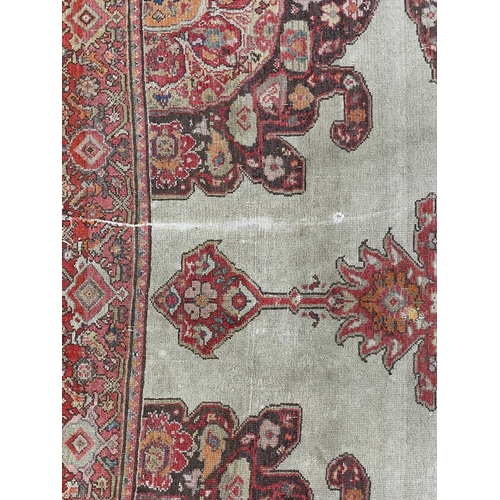 153 - A Malayer rug, West Persia, circa 1900. With a central lobed polychrome medallion, within a madder m... 