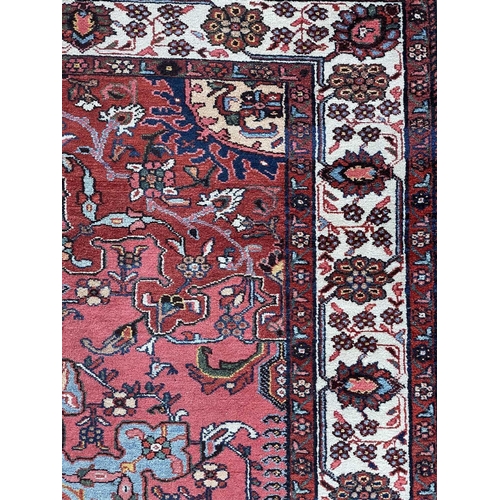 154 - A fine Hamadan rug, North West Persia, circa 1930's. The madder field with a pale blue and pink cent... 