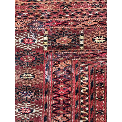 155 - A Tekke Turkoman rug, circa 1930. The madder field with twenty-one rows of three octagonal medallion... 