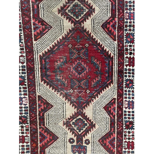 180 - A Sarab runner, North West Persia, circa 1930-1950. The camel field with three madder serrated pole ... 