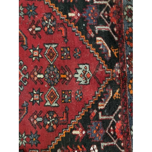 184 - A Hamadan rug, North West Persia, circa 1930's. The madder field with a central pale blue lozenge me... 