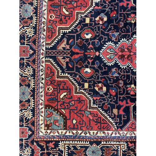 186 - A Hamadan rug, North West Persia, circa 1930. The indigo field with a large madder pole medallion, w... 