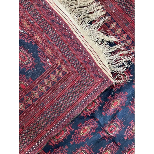 193 - A Pakistan rug, mid 20th century. The blue field with rows of multiple polychrome medallions, within... 