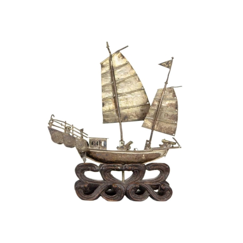 208 - A Chinese silver model of a junk, circa 1900. On a carved wood stand, height 12.5cm, width 11cm, dep... 