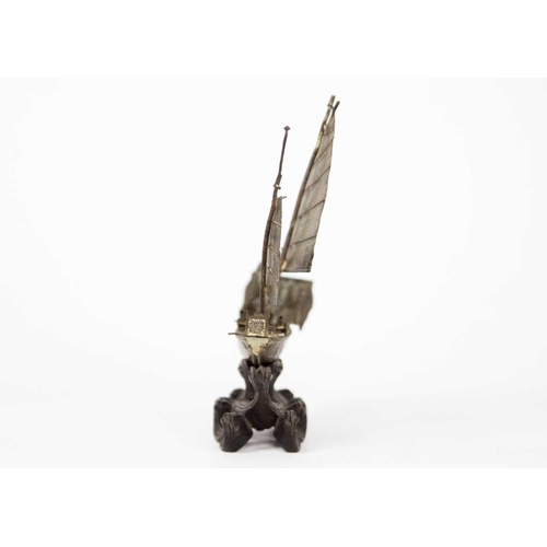 208 - A Chinese silver model of a junk, circa 1900. On a carved wood stand, height 12.5cm, width 11cm, dep... 