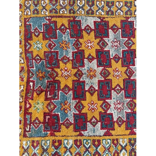 211 - A Moroccan rug, mid 20th century. The orange field with star rosette and square linked medallions, w... 