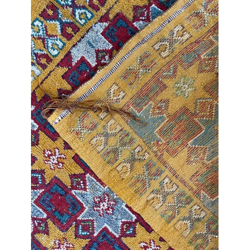 211 - A Moroccan rug, mid 20th century. The orange field with star rosette and square linked medallions, w... 