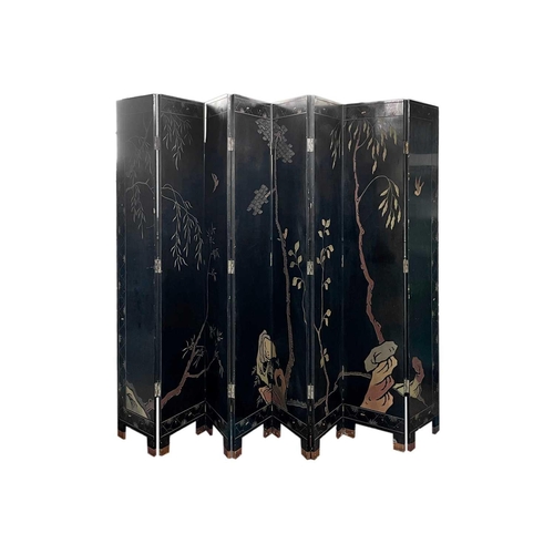 219 - A Chinese black lacquered screen, early 20th century. With eight panels, height 214cm.