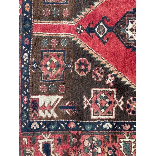 223 - A Hamadan rug, North West Persia, mid-late 20th century. The brown field with a large polychrome ser... 