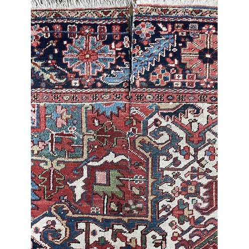 225 - A Heriz carpet, North West Persia, circa 1920. The madder field with polychrome pole medallion, serr... 