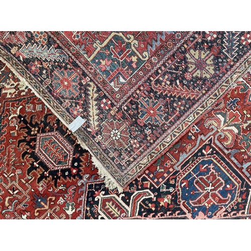 225 - A Heriz carpet, North West Persia, circa 1920. The madder field with polychrome pole medallion, serr... 