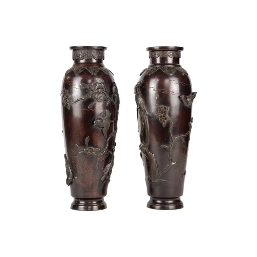 273 - A pair of Japanese bronze vases, Meiji Period. Decorated in high relief with birds, trees and foliag... 