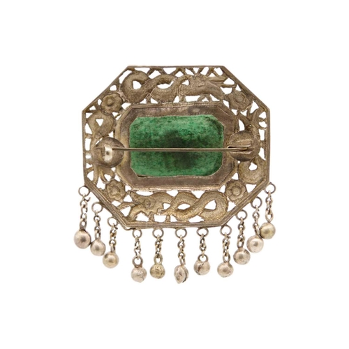 276 - A Chinese silver and green jadeite brooch. The mount embossed and pierced with coiled serpents among... 