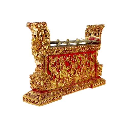 3 - An Indonesian carved wood xylophone, 20th century. Red painted and gilt decorated with figures and f... 