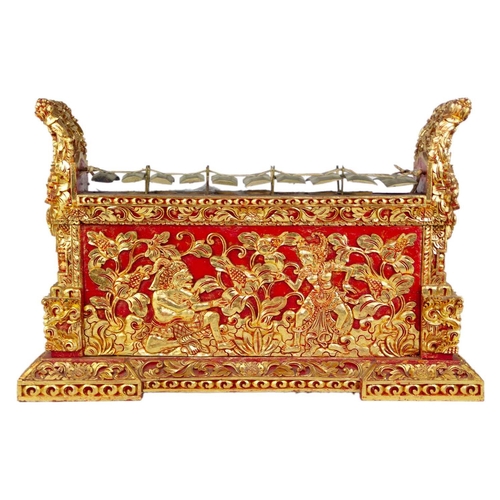 3 - An Indonesian carved wood xylophone, 20th century. Red painted and gilt decorated with figures and f... 