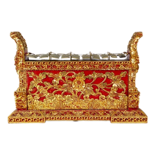 3 - An Indonesian carved wood xylophone, 20th century. Red painted and gilt decorated with figures and f... 