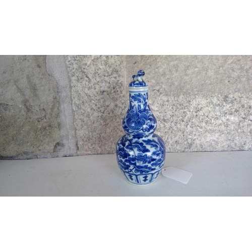 49 - A Chinese blue and white gourd vase, 19th century. Height 16.5cm, width 7.5cm. The cover has been gl... 