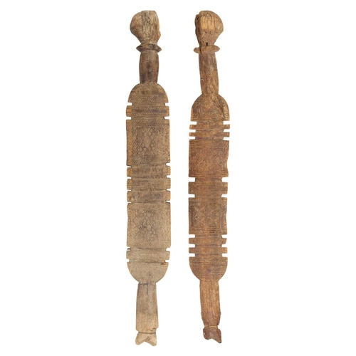 72 - Two Tuareg carved wood tent pegs. Each with bands of geometric motifs, height 76 and 72cm. (2)