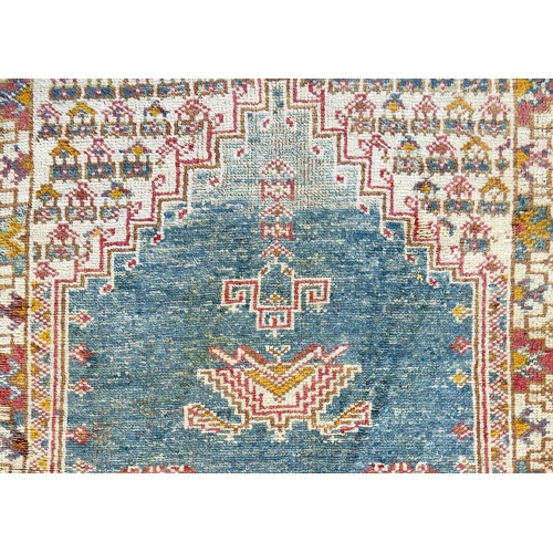 75 - A Turkish rug, circa 1930. The blue field with a blue abrash central medallion, ivory gul spandrels,... 