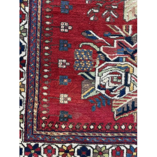 88 - An Afshar rug, South West Persia, circa 1930-1940. The red field with two central polychrome floral ... 