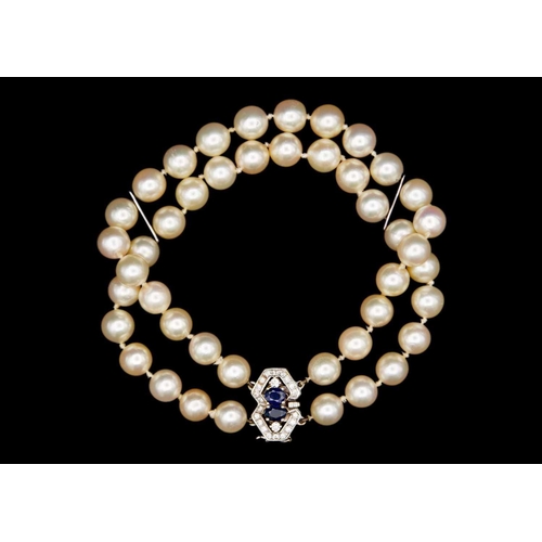 102 - A double row cultured pearl bracelet with 18ct diamond and sapphire set clasp. The 44 uniform cream ... 