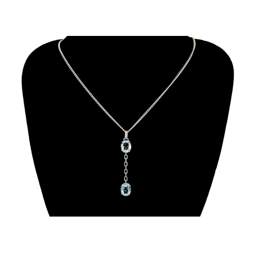 106 - An 18ct white gold blue topaz and diamond set pendant necklace. The pendant set with two topaz each ... 