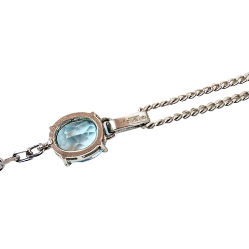 106 - An 18ct white gold blue topaz and diamond set pendant necklace. The pendant set with two topaz each ... 