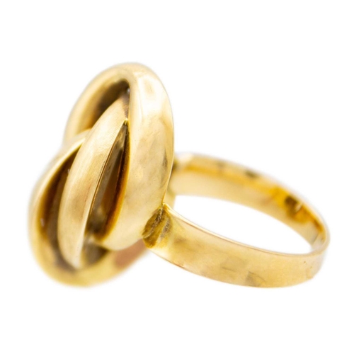 18 - An 18ct (tested) knot design ring. The hollow gold knot comprising three interlinked ovals, one is t... 