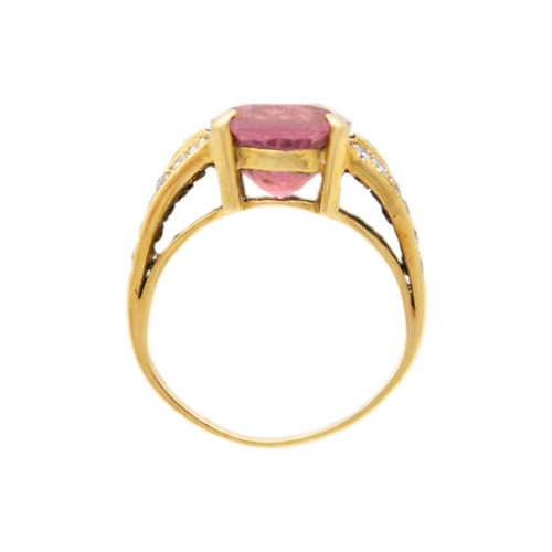 22 - An 18ct hallmarked gold pink Tourmaline and diamond set dress ring. The oval cut tourmaline weighing... 