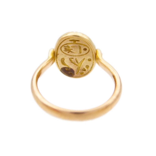 32 - A high purity gold (tests 14ct) Egyptian Revival scarab beetle swivel ring. The eyes set with small ... 