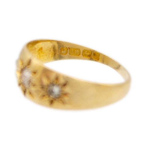 58 - An Edwardian 18ct hallmarked gold diamond set three-stone gypsy ring. The three stones star set, the... 