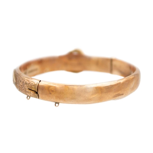 63 - An early 20th century 9ct rose gold hinged buckle bangle. Foliate scroll engraved, sponsors mark for... 