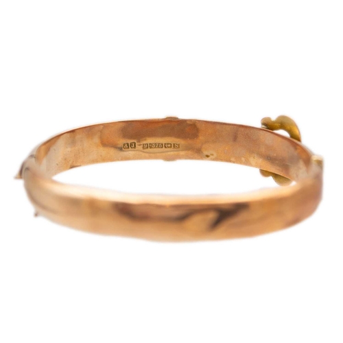 63 - An early 20th century 9ct rose gold hinged buckle bangle. Foliate scroll engraved, sponsors mark for... 