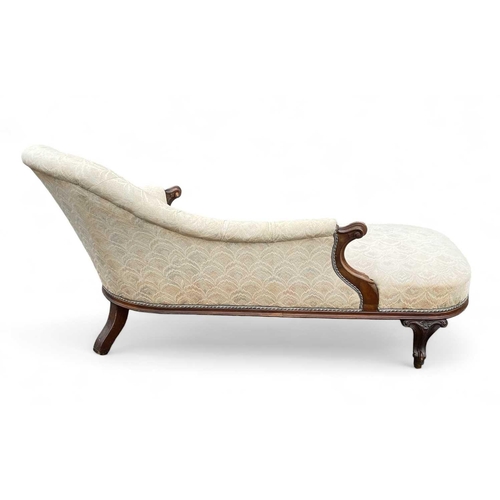 1014 - A Victorian walnut chaise lounge. On brass castor wheels, height 83cm width 170cm depth 79cm. Correc... 