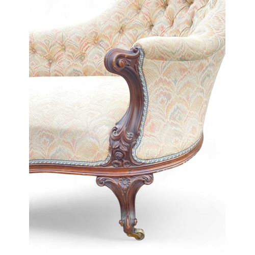 1014 - A Victorian walnut chaise lounge. On brass castor wheels, height 83cm width 170cm depth 79cm. Correc... 