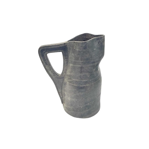 125 - A leather Jack jug. Height 30cm together with a pair of brass candlesticks, brass trivet, spiked fin... 