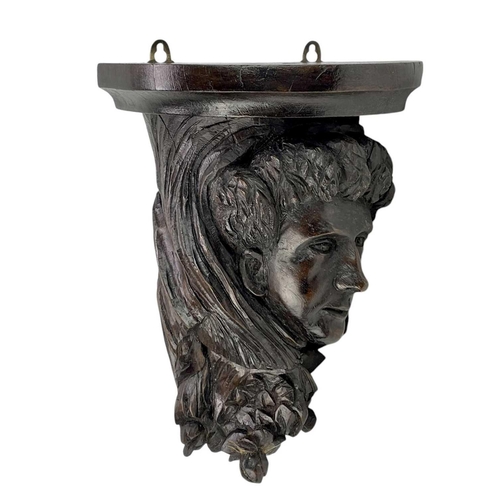 172 - A substantial carved oak wall bracket. 19th century, carved with a mask, drapery and foliage, height... 