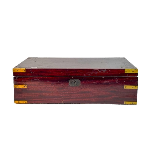 21 - A George IV mahogany and brass bound campaign writing box. With a fitted interior and side drawer, h... 