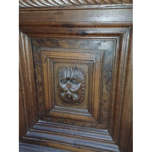 246 - An 18th century oak overmantle. Two panels with central lion masks within moulded borders flanked by... 