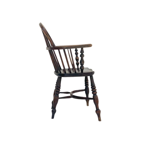 256 - An ash and elm Windsor armchair. With a pierced vase splat, shaped solid seat and a crinoline stretc... 