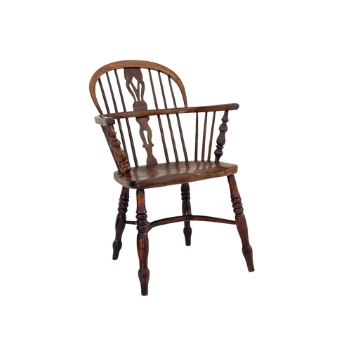 260 - An ash and elm Windsor armchair. with a pierced vase splat, solid seat and crinoline stretcher on tu... 