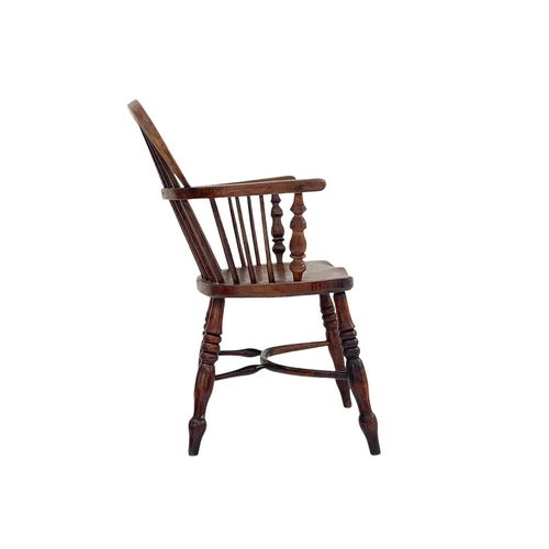 260 - An ash and elm Windsor armchair. with a pierced vase splat, solid seat and crinoline stretcher on tu... 