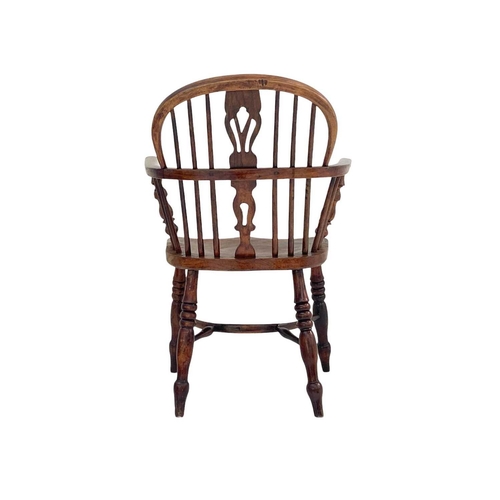 260 - An ash and elm Windsor armchair. with a pierced vase splat, solid seat and crinoline stretcher on tu... 