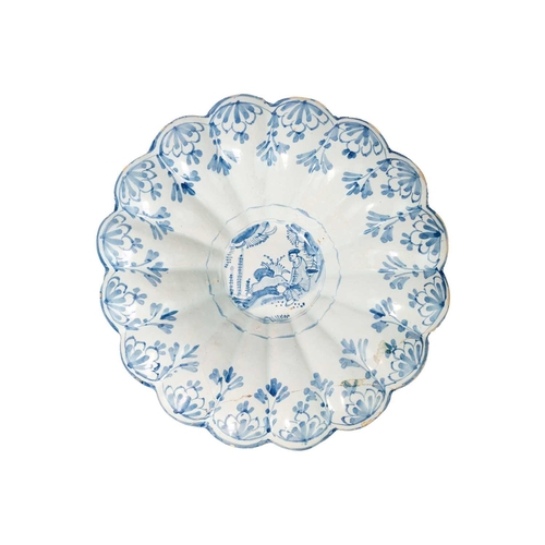 261 - A probably South German faience blue and white lobed dish. Decorated in Chinoiserie style, diameter ... 