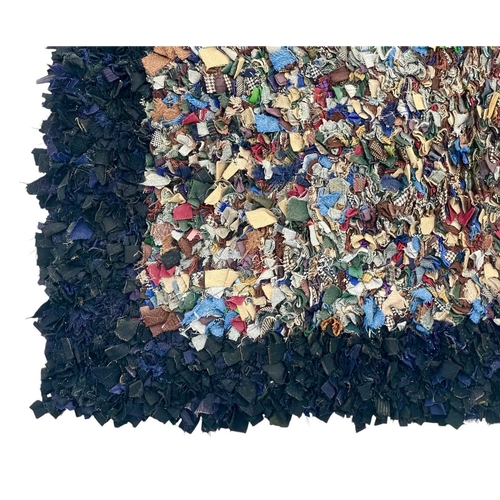 268 - A 'clippy' rag rug. Early-mid 20th century, worked with multiple woollen fabrics within a black bord... 