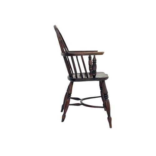 271 - An ash and elm Windsor armchair. With a pierced vase shape splat and raised on turned legs with a cr... 