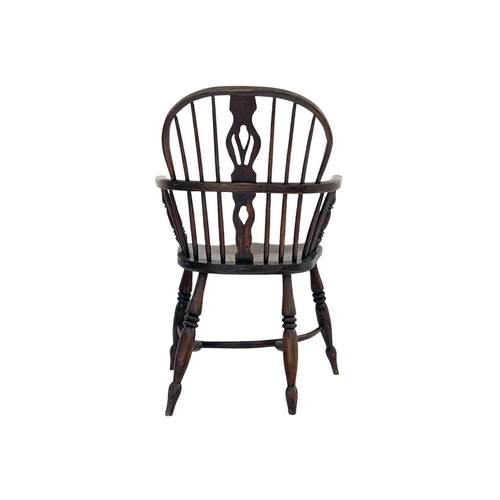 271 - An ash and elm Windsor armchair. With a pierced vase shape splat and raised on turned legs with a cr... 