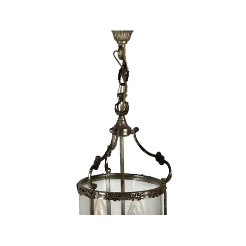 285 - A 20th century cast metal circular lantern. With triple light fittings and C scroll supports, height... 