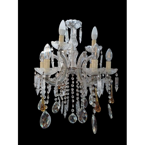 289 - A six branch cut glass chandelier. With C scroll arms trailing drops terminating with lustres, amber... 